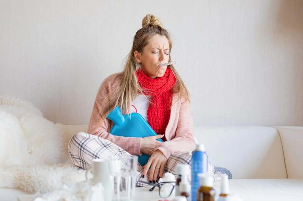 Chora kobieta mierząca temperaturę termometrem w ustach