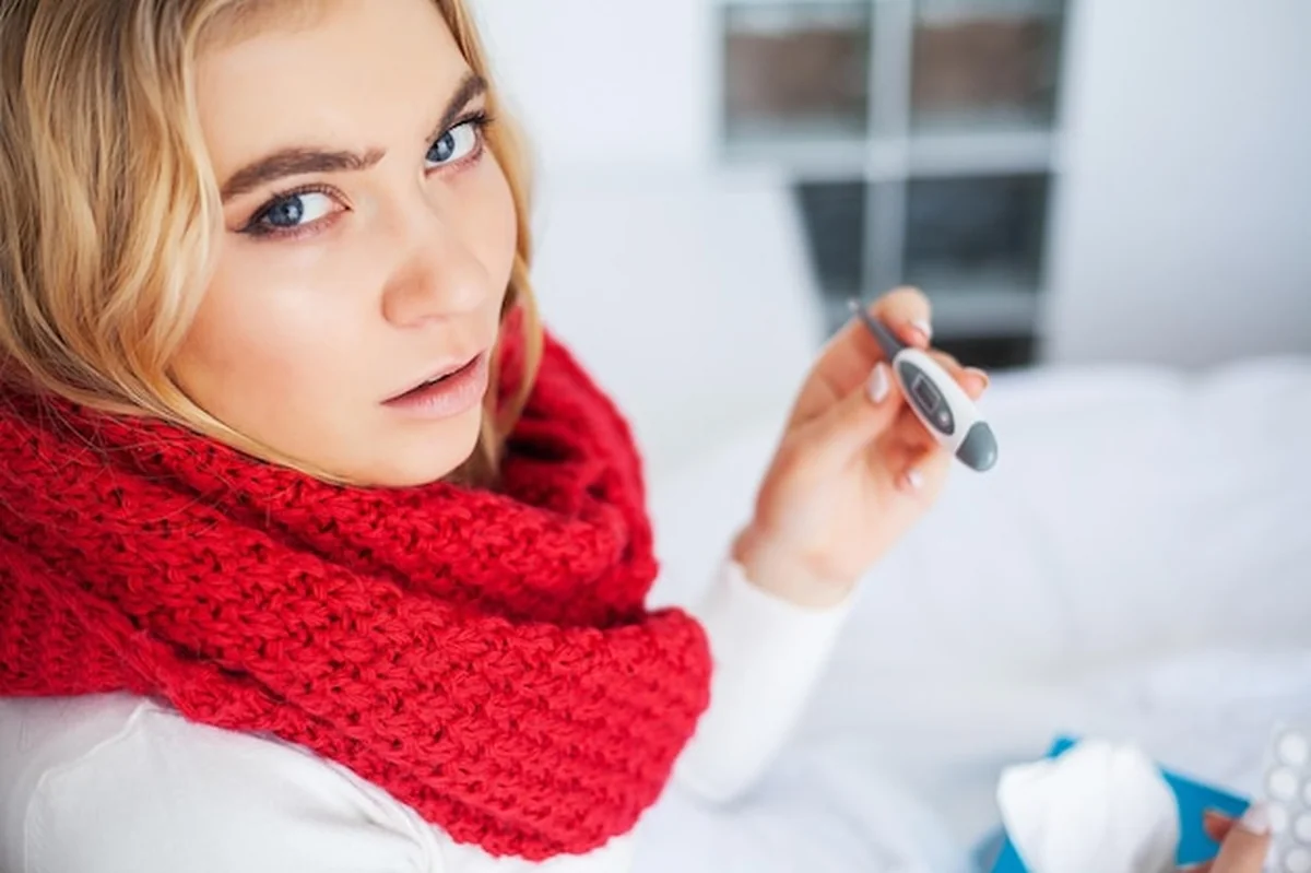 Chora kobieta z przeziębieniem leżąca w łóżku