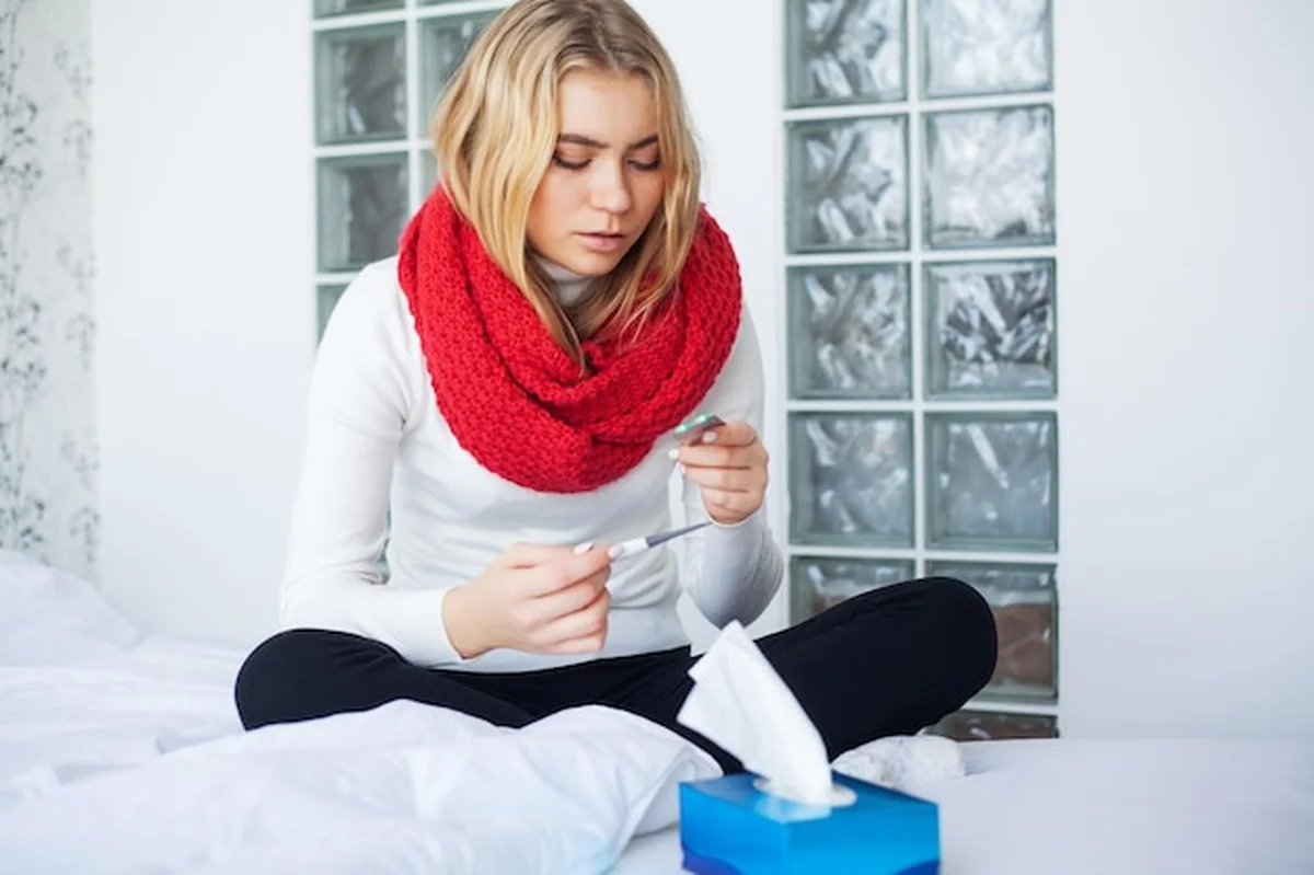 Chora kobieta z przeziębieniem leży w łóżku w domu