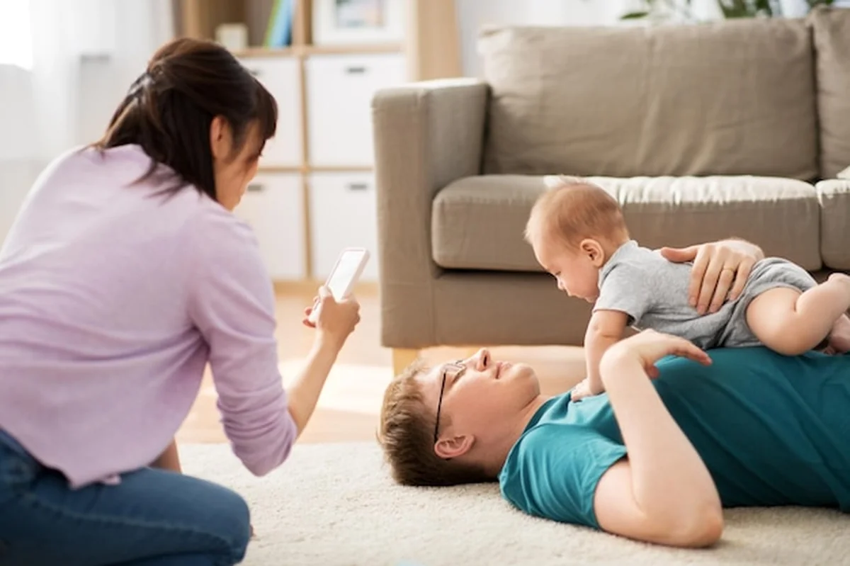 Matka pokazująca ojca z dzieckiem na smartfonie