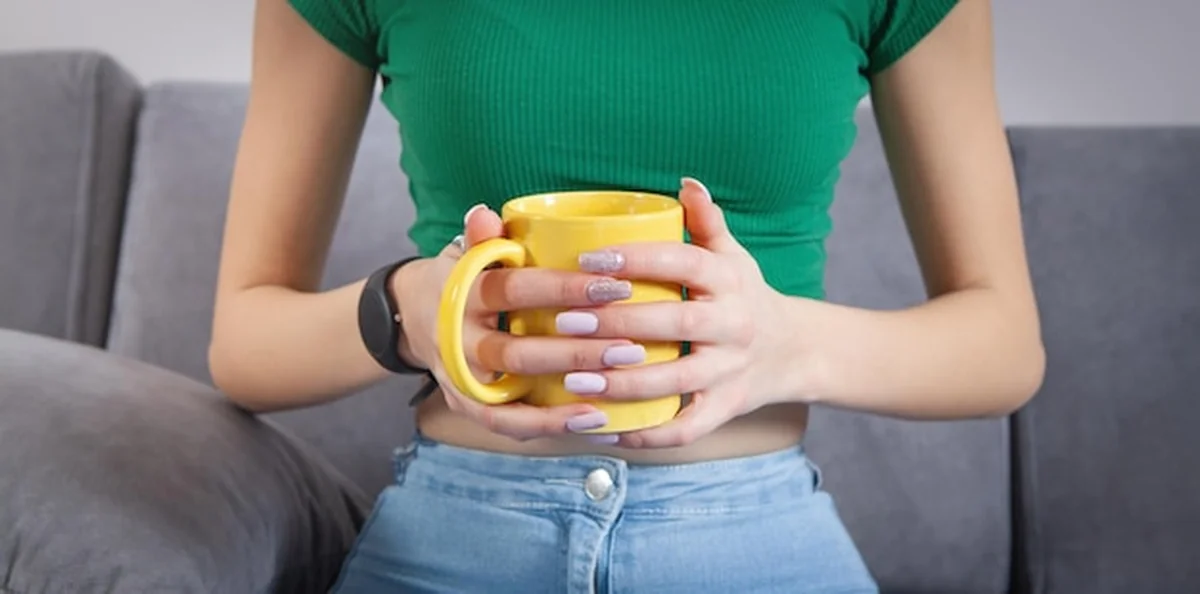 Kobieta trzyma filiżankę kawy lub herbaty