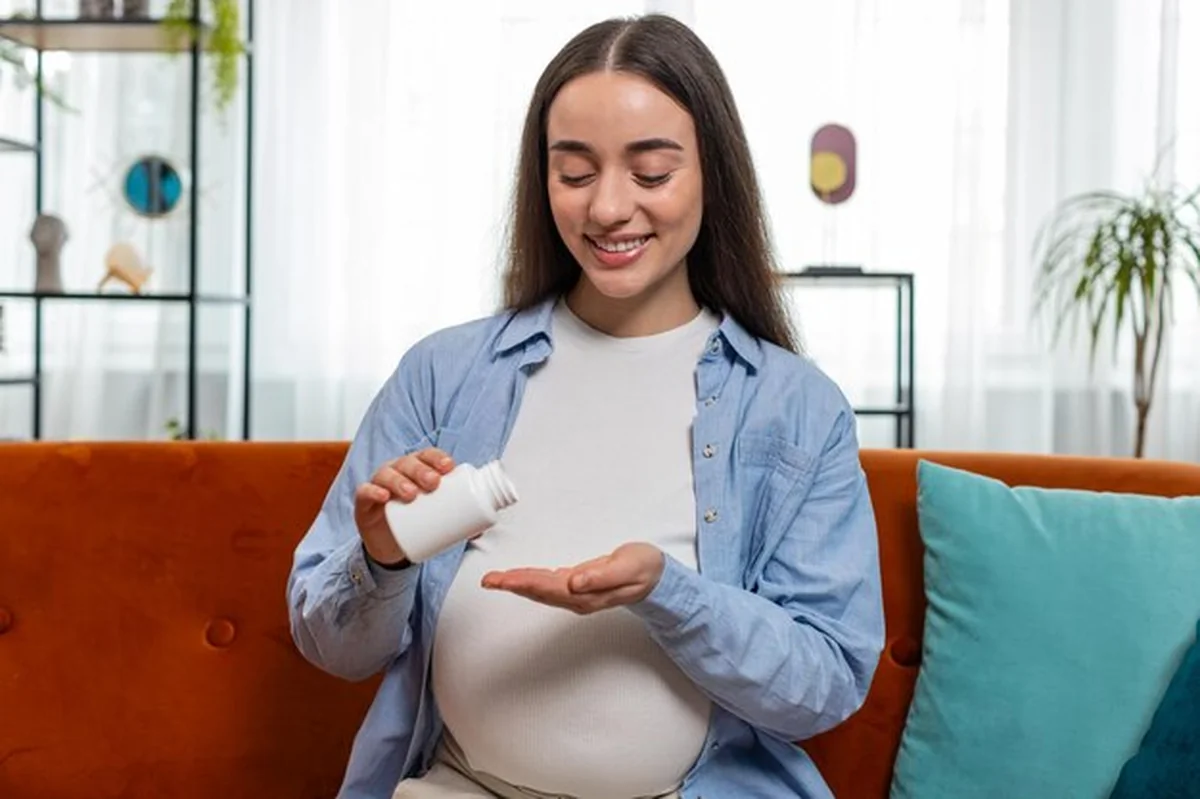 Ciężarna kobieta przyjmująca leki, pijąca wodę - zdrowa ciąża