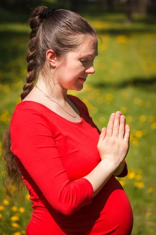 Kobieta w ciąży wykonuje asanę tadasanę na zewnątrz