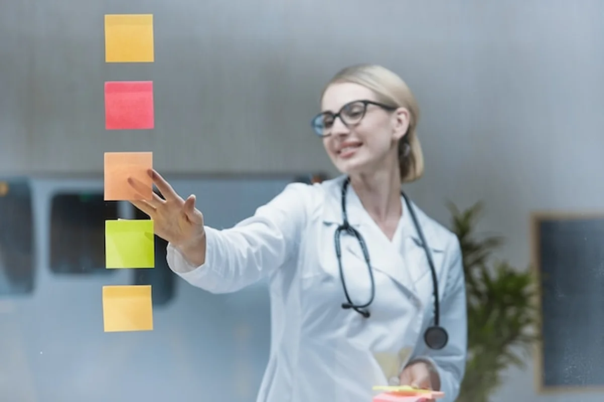 Lekarka przykleja naklejki do przezroczystego szkła