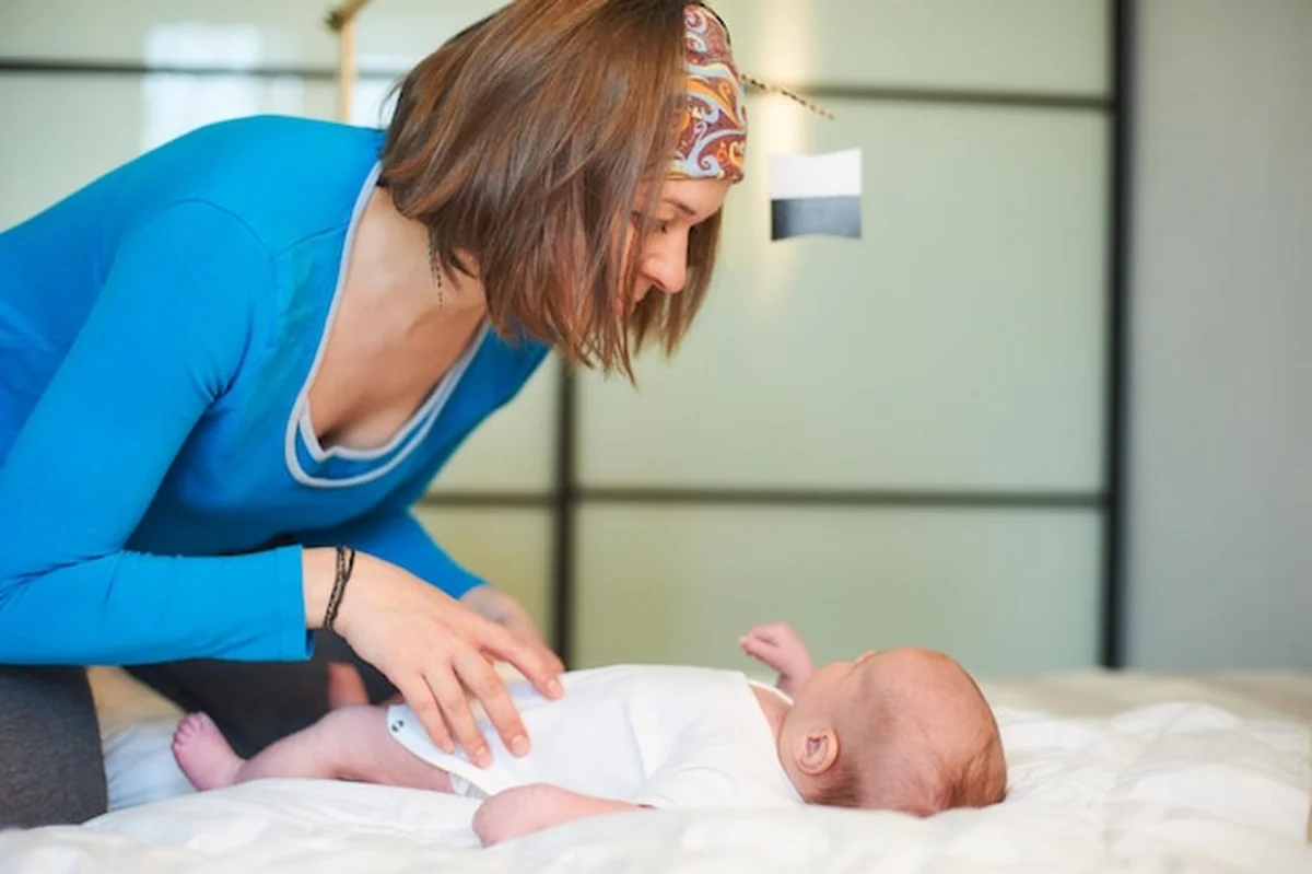 Matka bawiąca się z noworodkiem w przytulnym otoczeniu w ciągu dnia