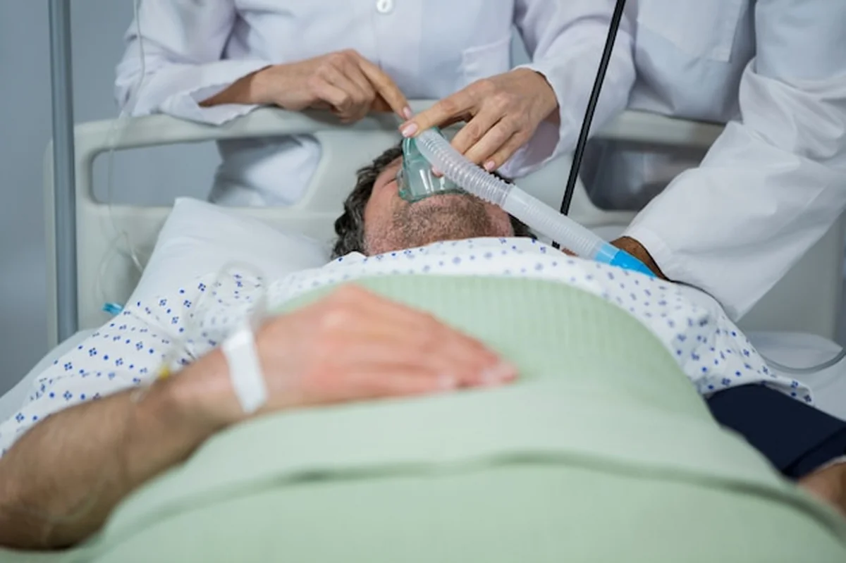 Lekarz nakłada maskę tlenową na twarz pacjenta